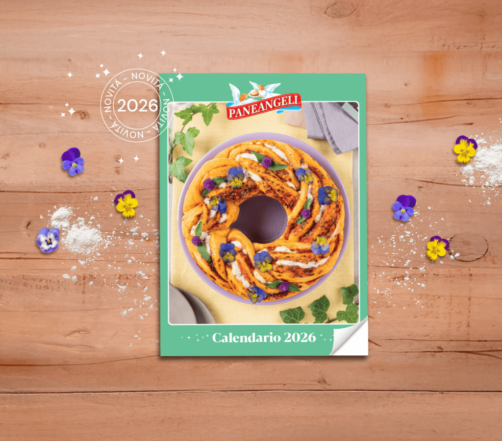 Calendario Paneangeli 2026 con copertura verde, mostrante un dolce decorato con fiori commestibili e posizionato su un tavolo di legno, circondato da farina e fiori